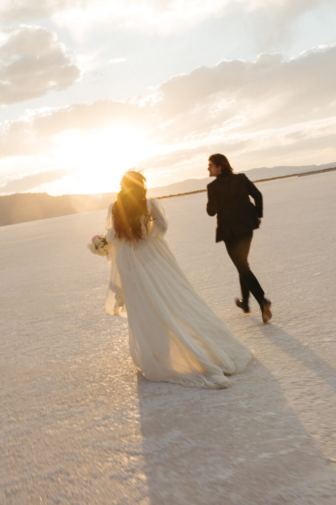 Bride and groom running at golden hour during elopement at Bonneville Salt Flats in Utah.